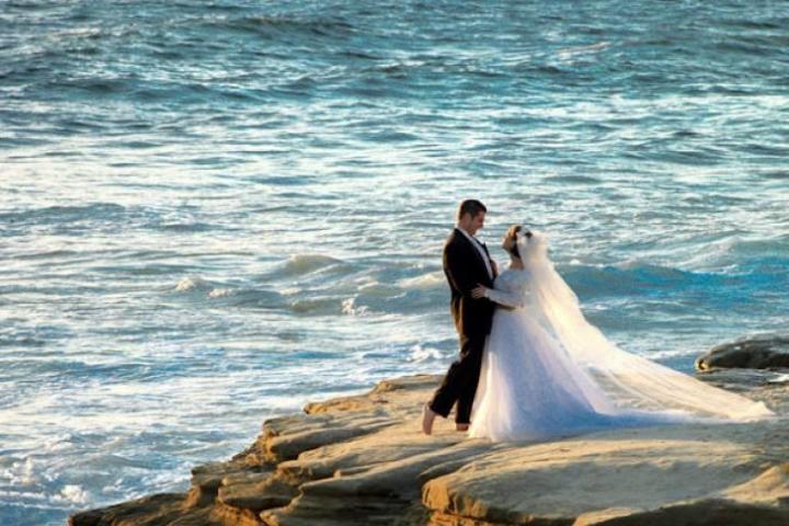 A portrait of a bride and groom by the ocean