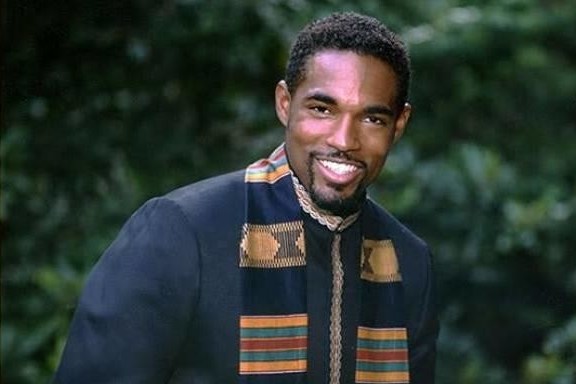 A portrait of a man with a leafy background