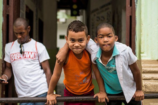 Two kids leaning over a bar