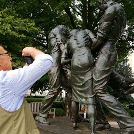 A man photographing a sculpture