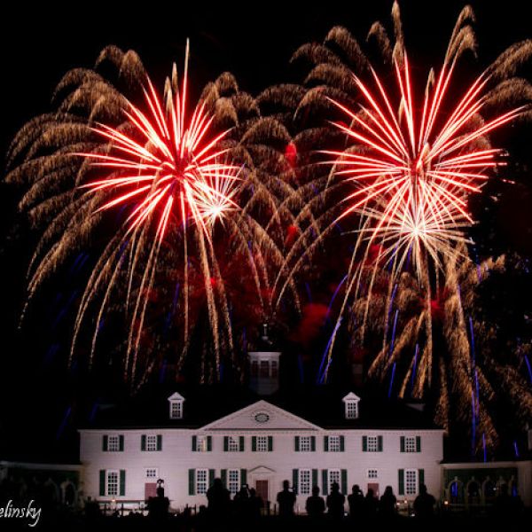 Fireworks over a white mansion