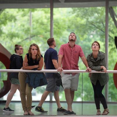 Three people waiting and looking around a museum