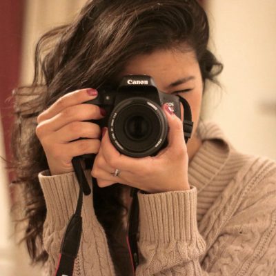 A Photographer with her face hidden by her camera