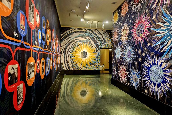 National Academy of Sciences colorful hallway with historical timeline and cosmic-themed murals on walls.